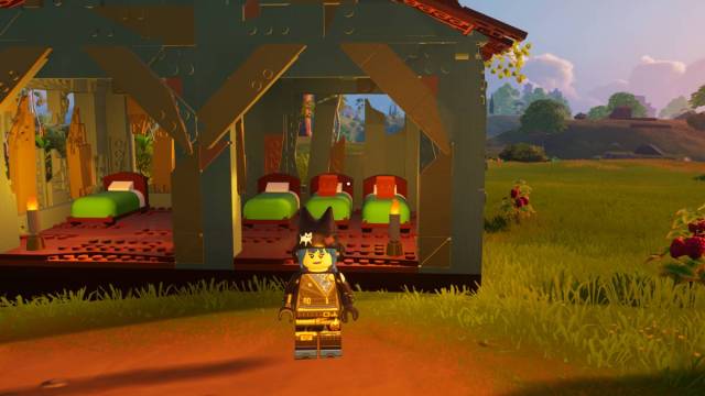 Minifigura Lego de Fortnite parada frente a las camas y la estructura.