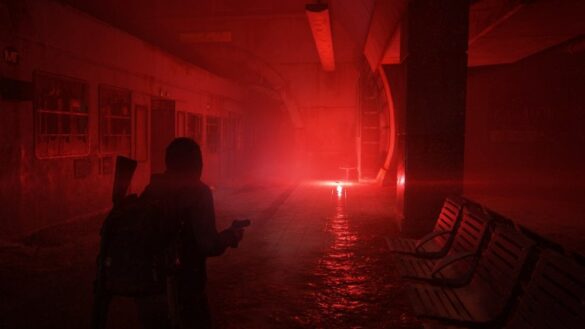 Ellie walking through dark subway lit by a red flare.