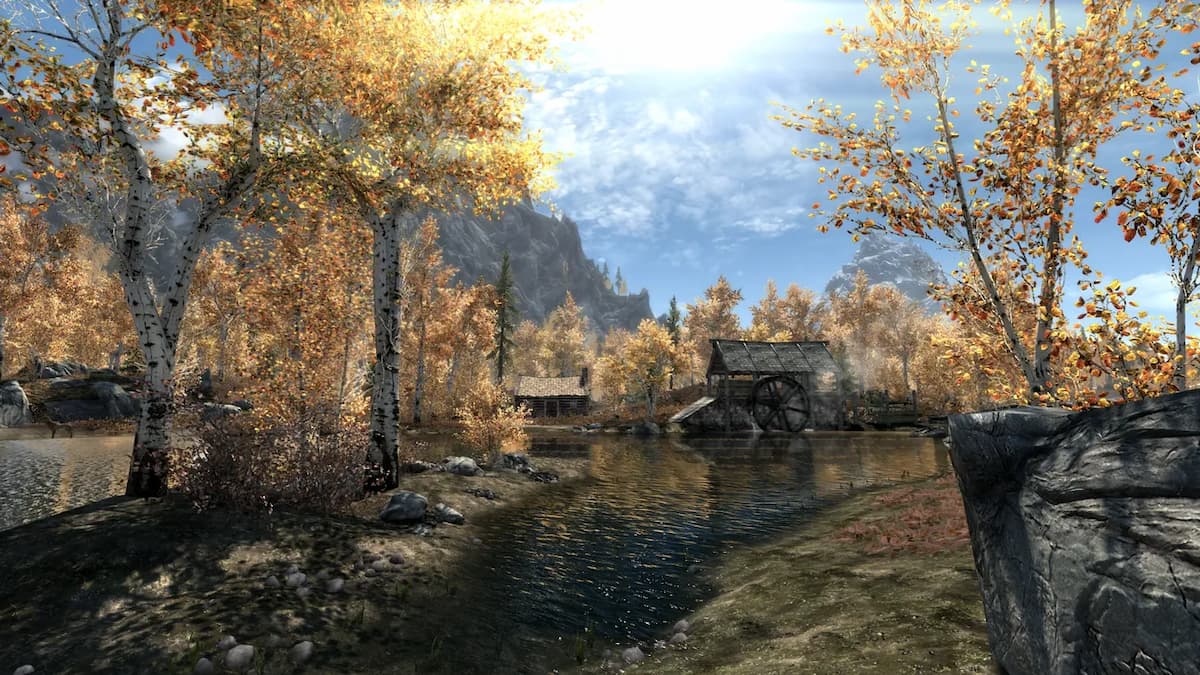 paisaje otoñal en skyrim de árboles de hojas amarillas y una pequeña aldea