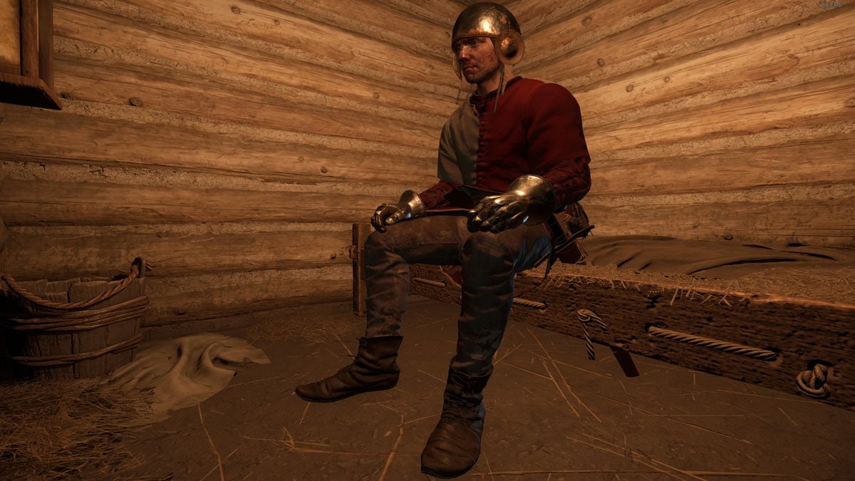 Henry sentado en una cama para dormir y salvar el juego en Kingdom Come Deliverance 2